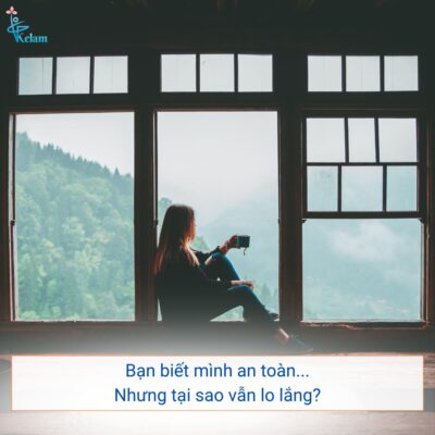 Người phụ nữ ngồi một mình với vẻ mặt lo lắng, minh họa tình trạng biết mình an toàn nhưng vẫn không kiểm soát được cảm giác lo âu và hoảng loạn.